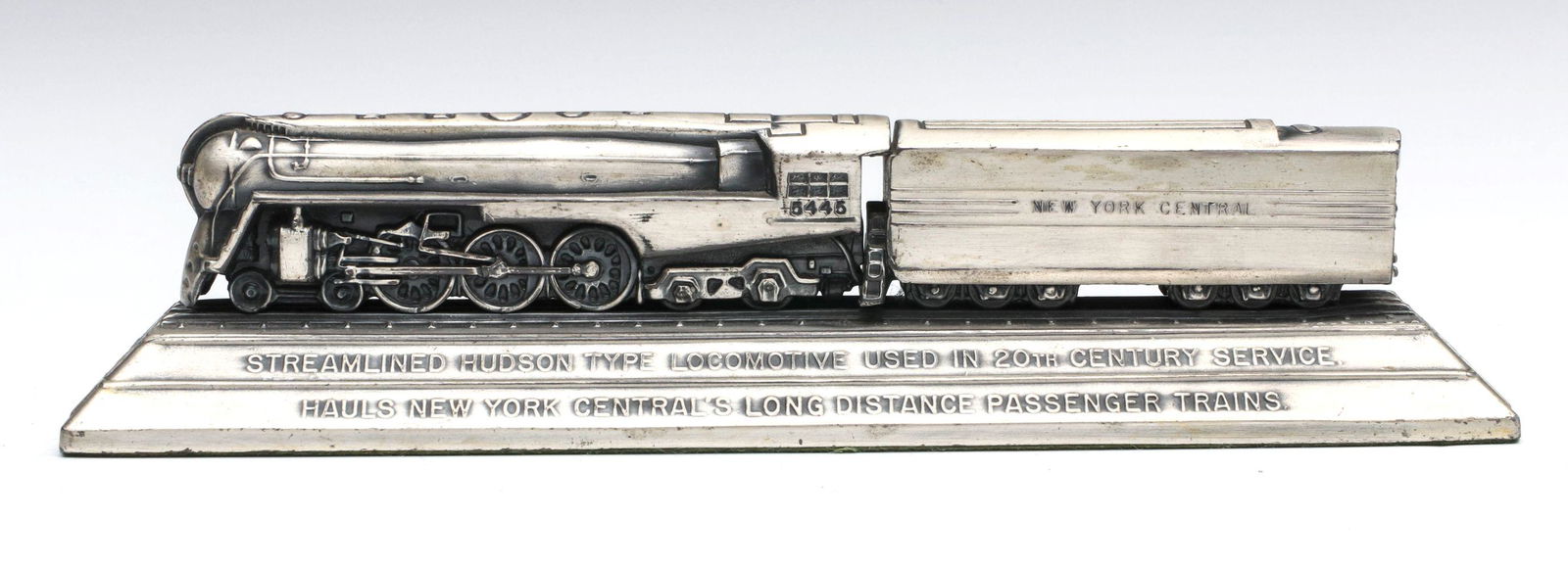 A STREAMLINED NYC RR HUDSON LOCOMOTIVE DESK ORNAMENT: A model of the Hudson Type Locomotive designed by Henry Dreyfuss, used in 20th Century Passenger Train Service. silvered white metal with felt base. Measures 2.75 x 10.5 x 2.5 inches. Provenance: The