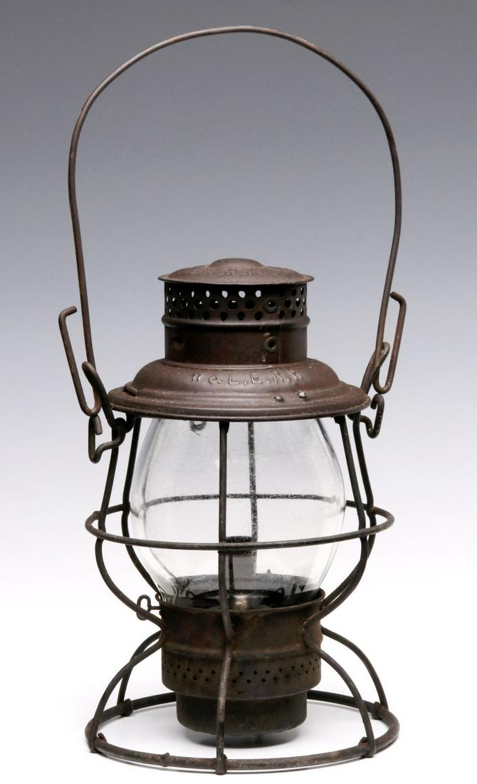 A WHEELING & LAKE ERIE RAILROAD ADLAKE RELIABLE LANTERN: The wire-bottom lantern with single guard, embossed lettering of W.&L.E.R.R. on the smoke dome, signed ADLAKE RELIABLE on the cap, a tall clear globe signed Cmx for Corning Glass. Measures 10.5 x 7.5 