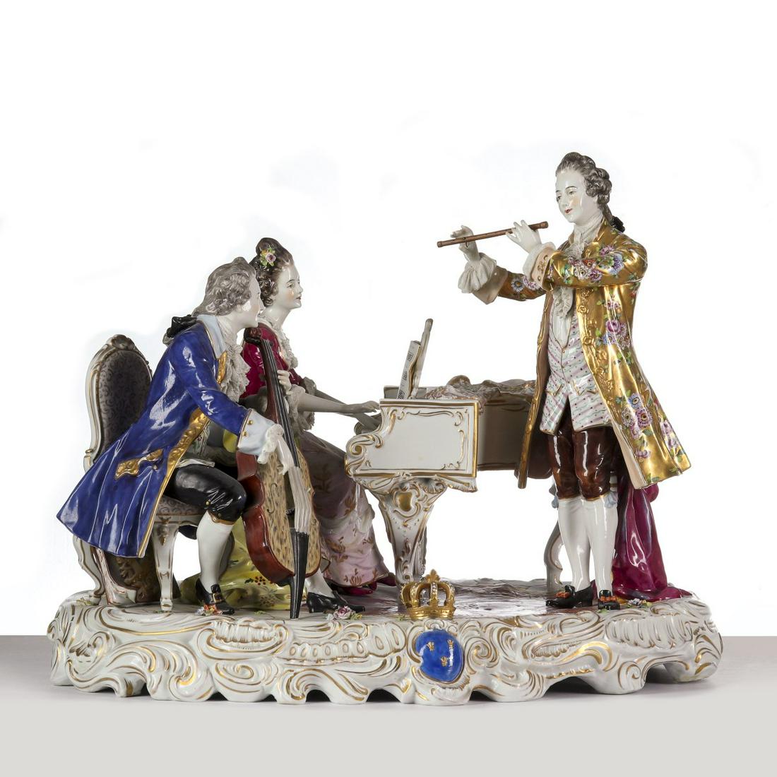 A MONUMENTAL CONTINENTAL PORCELAIN GROUPING CIRCA 1890: The trio of musicians in 18th century dress, some with elaborately decorated clothing with gilt decoration, the three upon an elaborate rococo rococo base with colorful enamels, figural crown with los