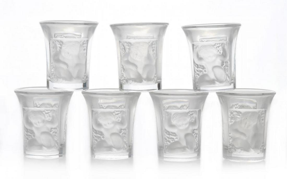 LALIQUE 'ENFANTS' CRYSTAL SHOT GLASSES: Seven vintage Lalique crystal shot glasses in the 'Enfants' pattern, engraved signatures on the bases.We happily provide seamless in-house packing and shipping services on nearly everything we sell.