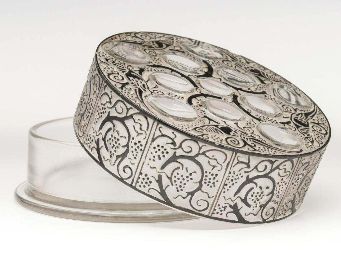 LALIQUE 'ROGER' FRENCH CRYSTAL DRESSER BOX: A Lalique French crystal powder box in clear, frosted and enameled glass, Roger pattern with vines and birds, engraved France only on the base.We happily provide seamless in-house packing and shipping