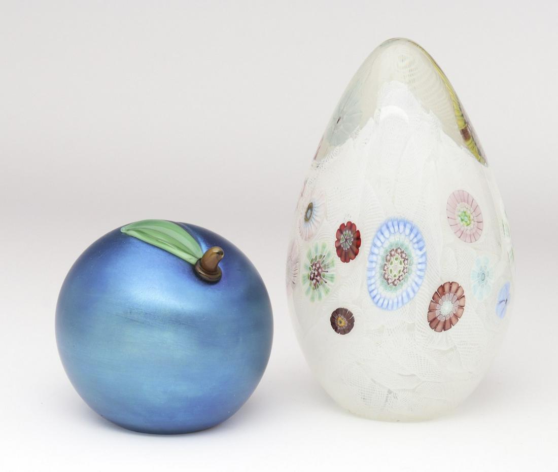 TWO ART GLASS PAPERWEIGHTS SIGNED ORIENT AND FLUME: Late 20th Century.One in blue iridescence and the form of a plum, plus a millefiori example with internal latticino decoration, both signed on their base.We happily provide seamless in-house packing a