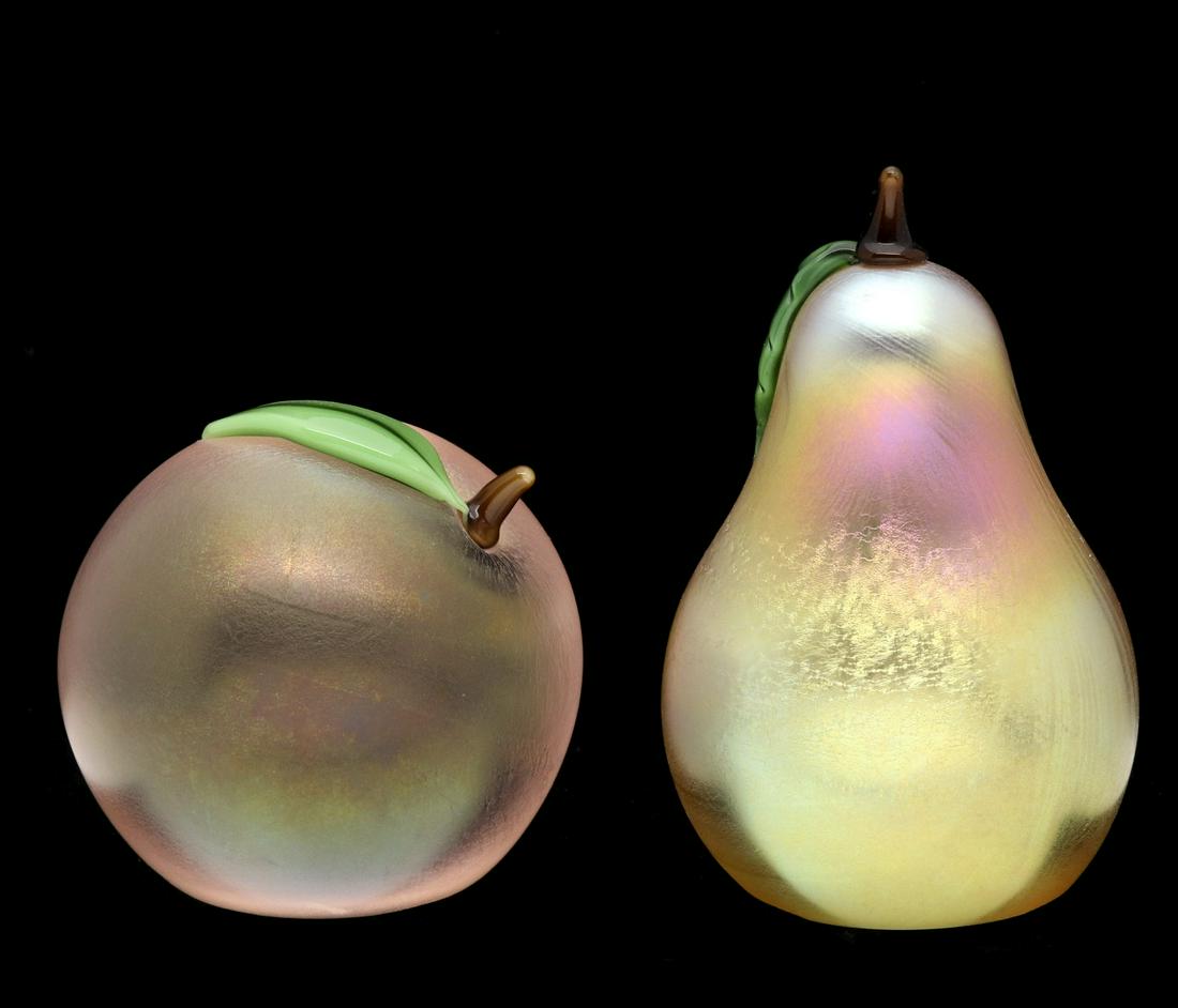 ART GLASS FRUIT PAPERWEIGHTS SIGNED ORIENT & FLUME: Late 20th Century.Apple and pear form art glass paperweights with iridescent finish and signed with foil sticker and engraved signatures on the bases.We happily provide seamless in-house packing and s