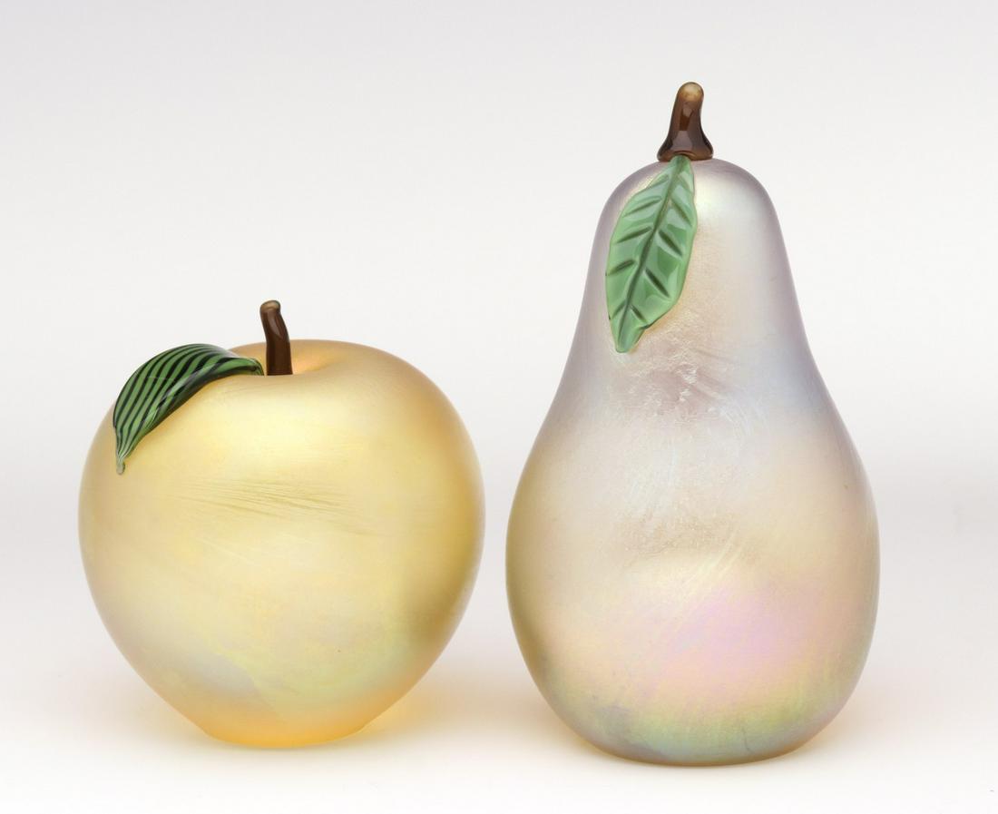 ART GLASS FRUIT PAPERWEIGHTS SIGNED ORIENT & FLUME: Late 20th Century.Apple and pear form art glass paperweights with iridescent finish and signed with foil sticker and engraved signatures on the bases.We happily provide seamless in-house packing and s