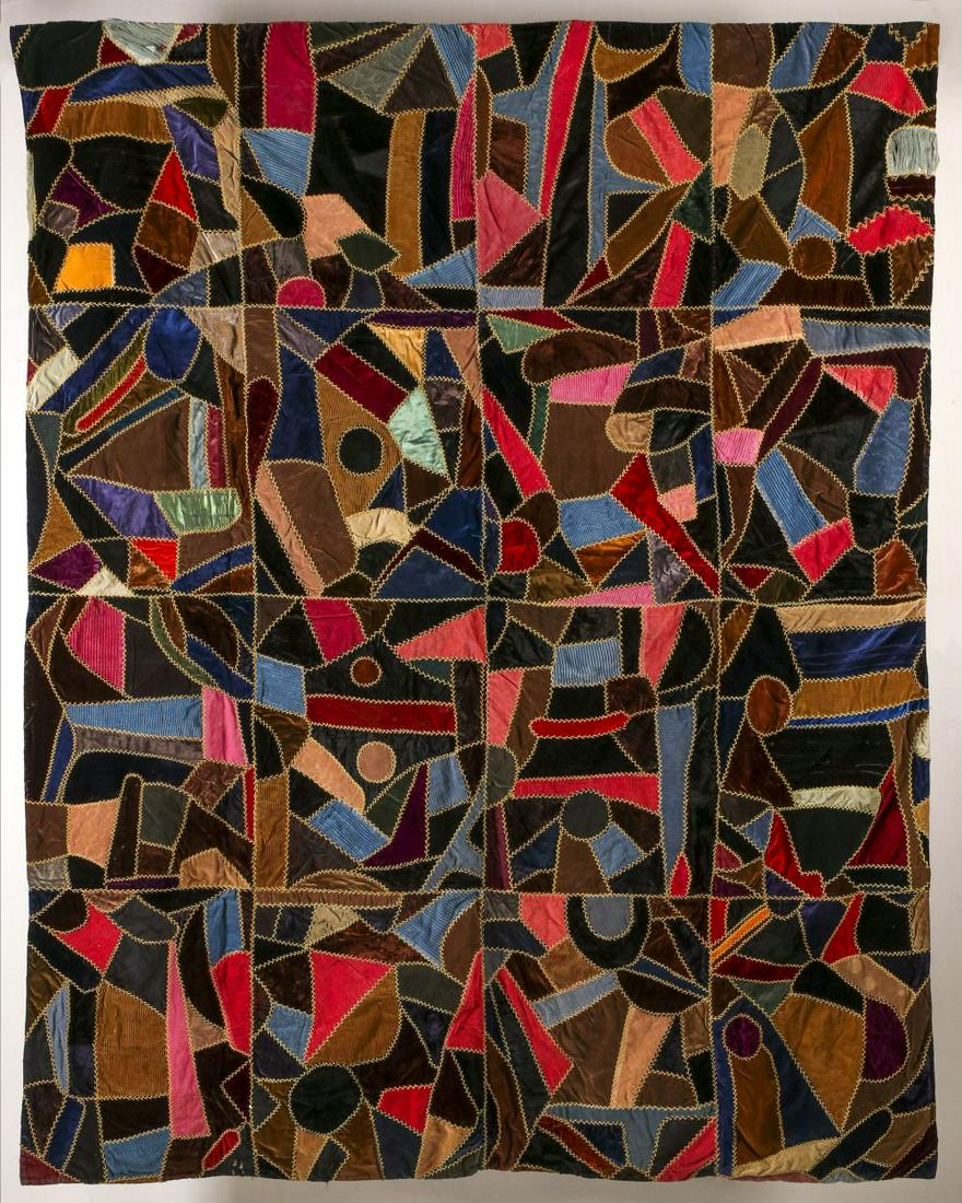 AN INTERESTING ANTIQUE ABSTRACT CRAZY QUILT: The sixteen rectangular blocks of crazy quilt technique incorporating circles and geometrics with odd shapes in abstract designs of velvet, silks, satins and corduroy with gold feather stitch embroide