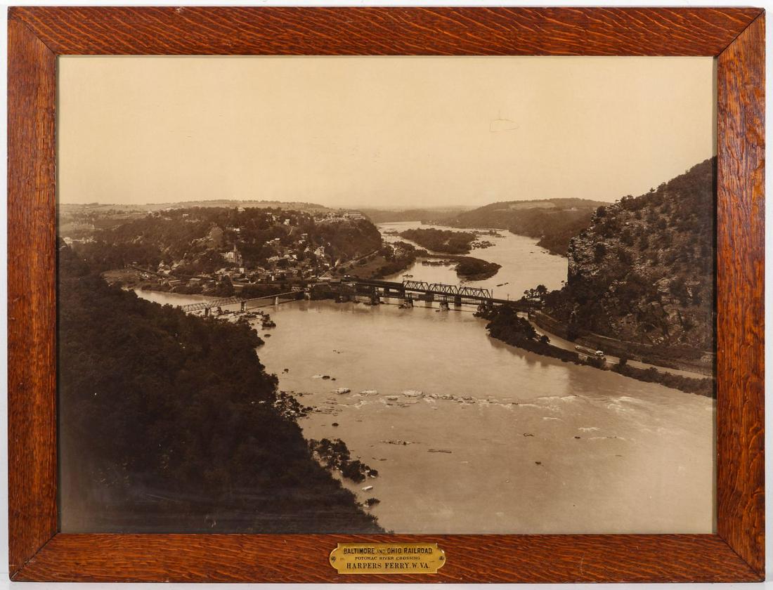A PHOTOGRAVURE VIEW NEAR HARPER'S FERRY WV ON THE B&O: The large photomechanical sepia tone image in period quarter-sawn tiger oak frame with original brass plaque identifying the view as POTOMAC RIVER CROSSING HARPERS FERRY. W. VA. Sight size is 28.5 x 3
