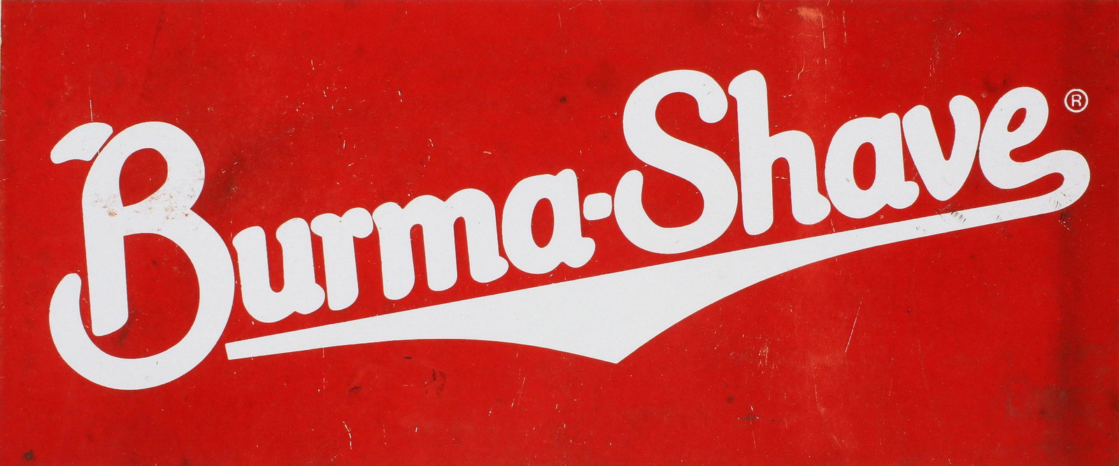 A BURMA-SHAVE PORCELAIN ENAMEL ADVERTISING SIGN: The two-color sign advertising Burma-Shave, single-sided porcelain with mounting holes on each corner. Measures 6 x 12 inches. We happily provide seamless in-house packing and shipping services on nea