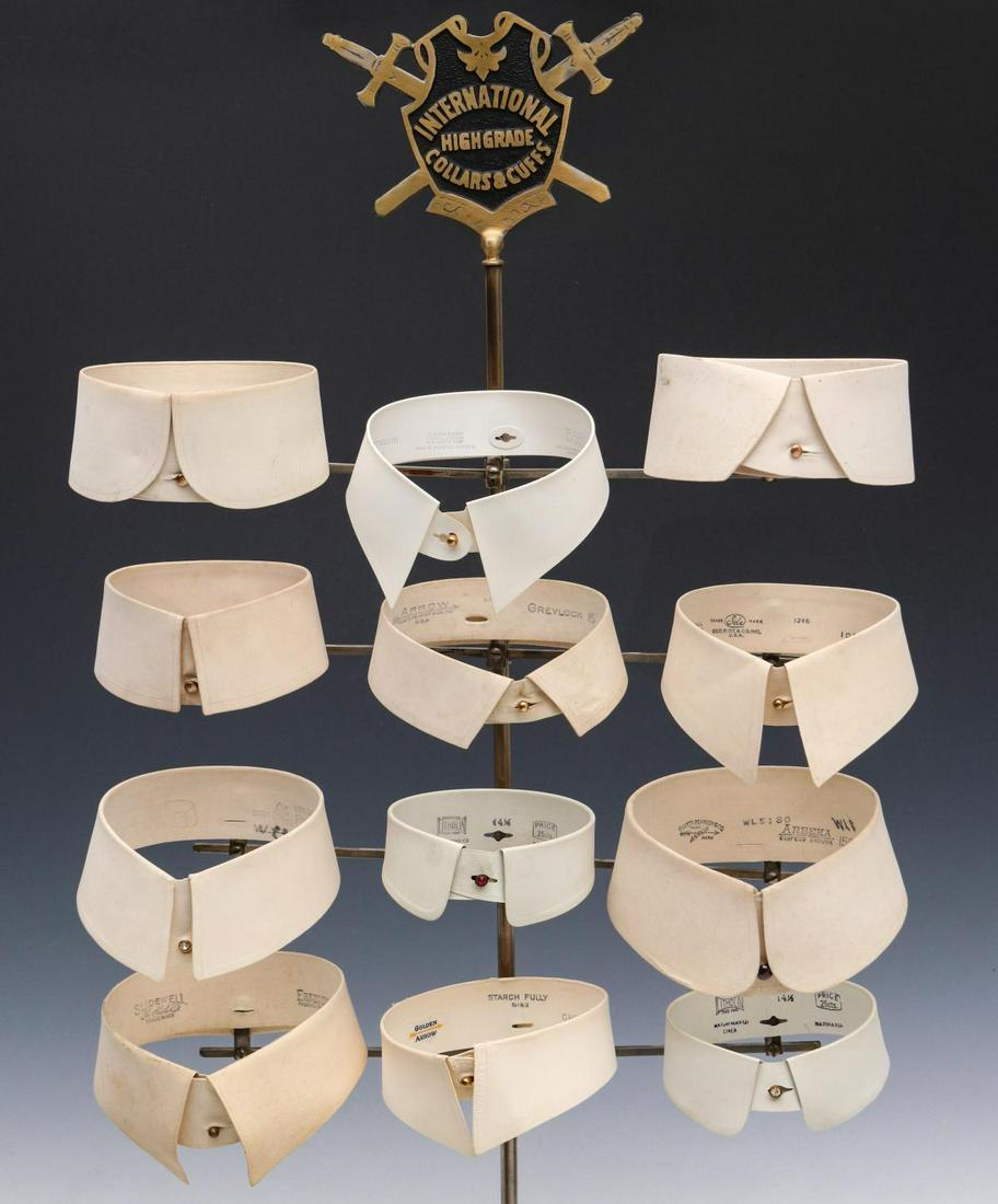 STORE DISPLAY FOR INTERNATIONAL COLLARS AND CUFFS: The counter-top store display with brass plaque surmount and arms with clips for collar display. Measures 35 x 17 x 6 inches. We happily provide seamless in-house packing and shipping services on near