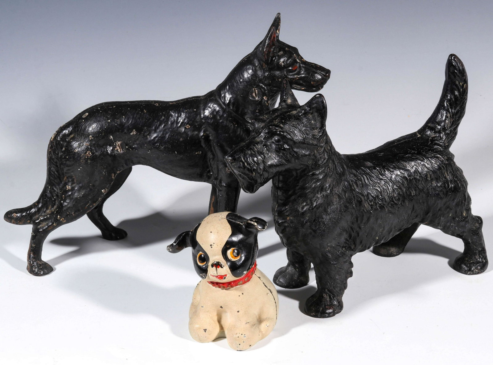 THREE GOOD HUBLEY CAST IRON DOG FIGURAL DOORSTOPS: The Hubley cast iron doorstops in original paint, the smaller with collar embossed FIDO serves as a bank or doorstop, no markings. Sizes range from x 12 x 2.5 to 5 x 3.25 x 4 inches. We happily provid