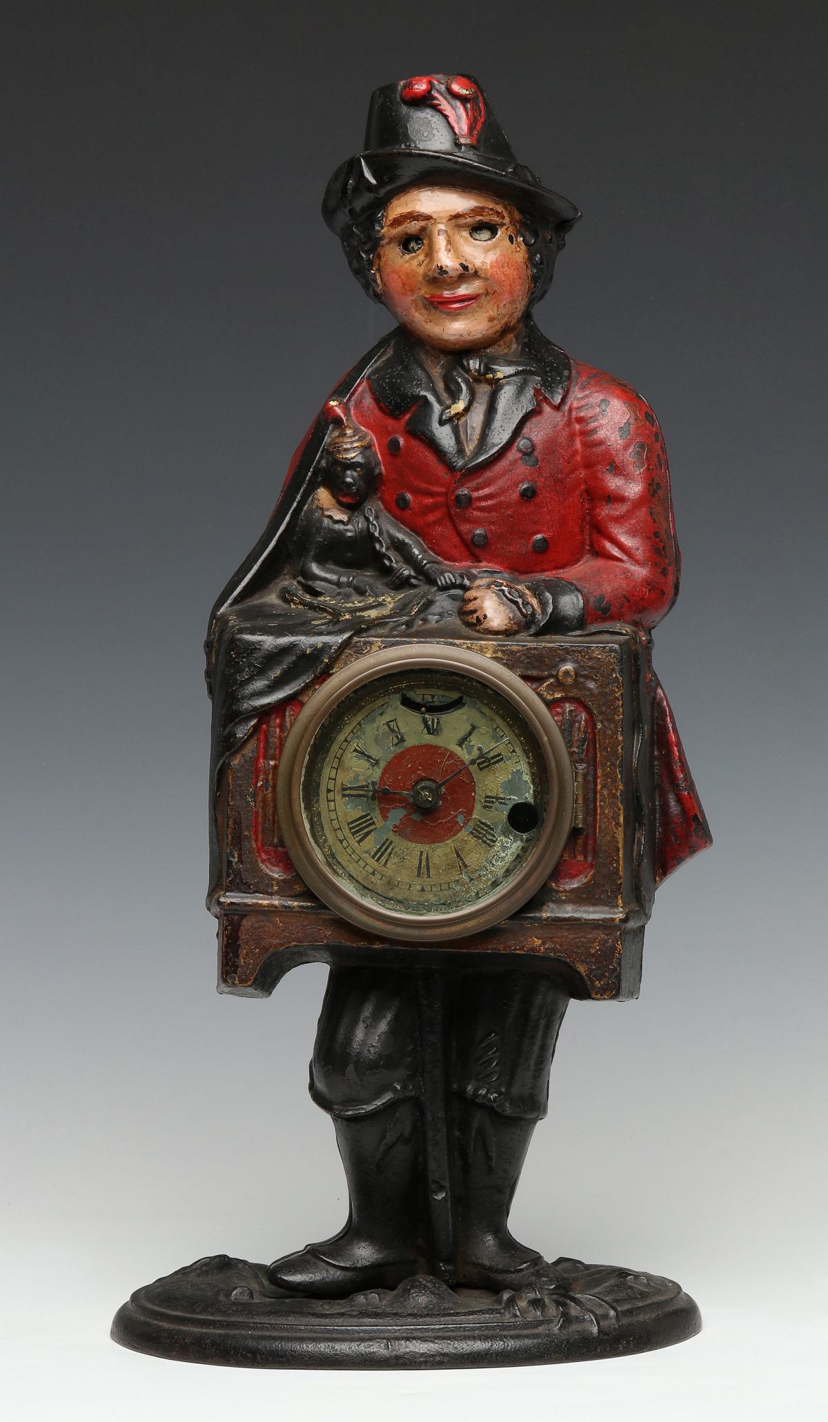 A BRADLEY & HUBBARD ORGAN GRINDER ANIMATED IRON CLOCK: The high quality cast iron clock with animated moving eyes, figure of an organ grinder with monkey and hand organ centered by a time-only clock with two-color painted metal dial, the figure with nicel
