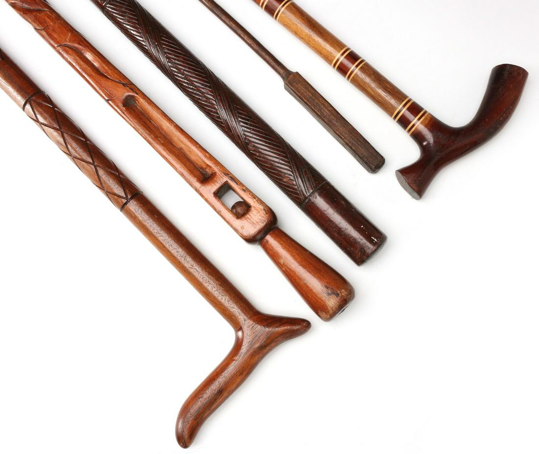 FIVE VINTAGE AND ANTIQUE WOOD WALKING STICKS: The carved and inlaid walking sticks and canes as shown. Measure 34.5 to 36 inches. We happily provide seamless in-house packing and shipping services on nearly everything we sell.