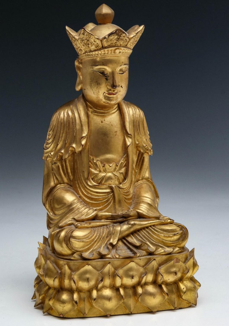 A FINE 19TH CENTURY GILT WOOD FIGURE OF BUDDHA: Seated wearing half-open robes in dhyanasana, the arms held in the lap in dhyana or samadhi mudra, a crown-like hat upon his head, and on an elaborate integral base. Measures 9 x 5 x 4.25 inches.