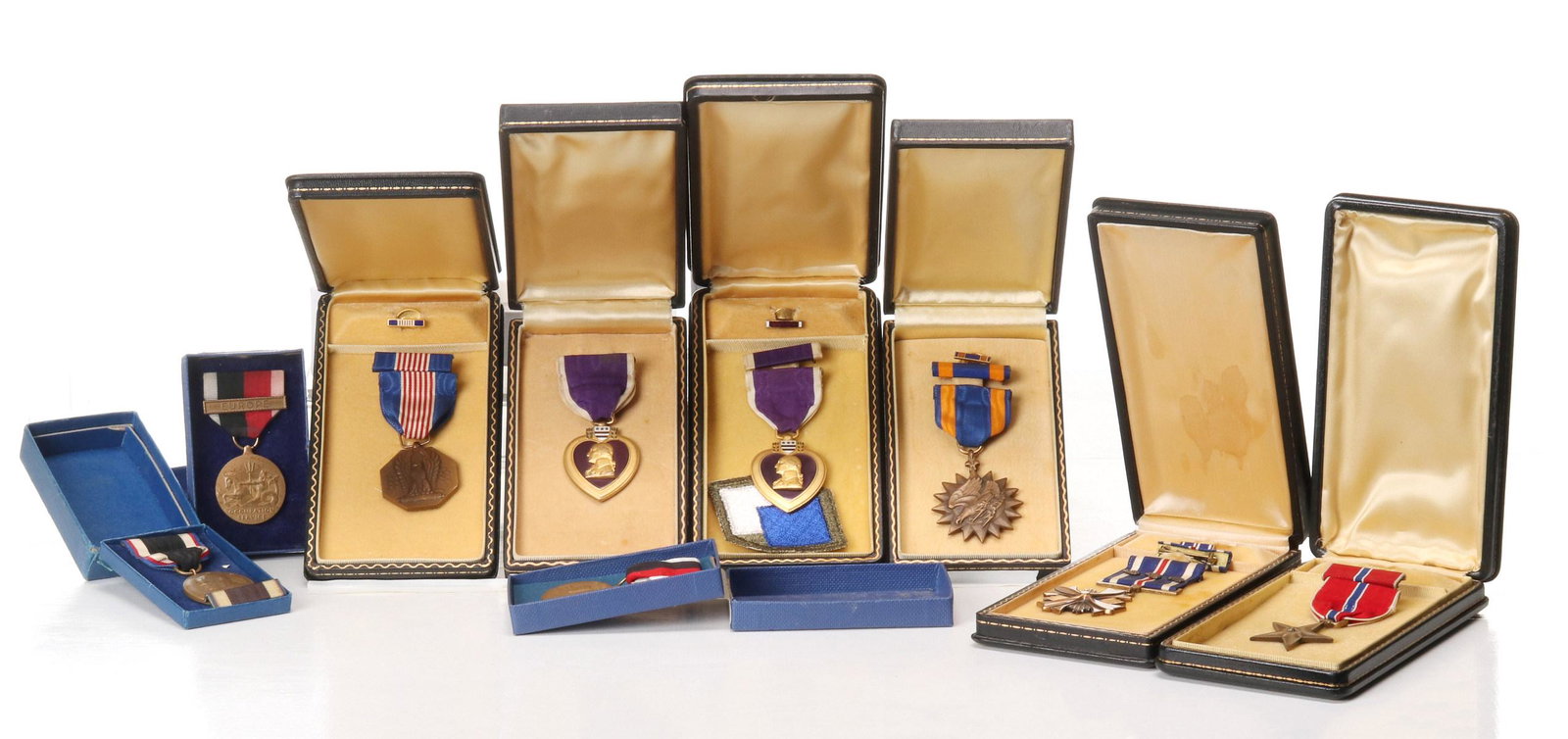 KIA PURPLE HEART, BRONZE STAR, DFC, OTHER NAMED AWARDS: A collection of named, cased and other important WWII medals and decorations. Bronze Star Medal with ribbon and lapel pin, cased, named to Capt. Charles W. Jones, with two news clippings and Immunizat