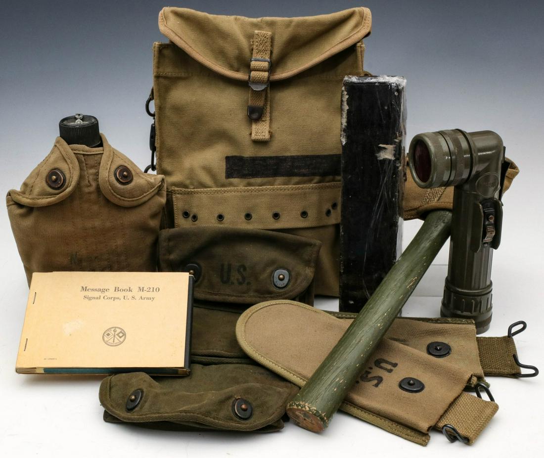 A COLLECTION OF US WWII FIELD GEAR: Field gear includes: Message book M-210. Medic's pouch with shoulder strap. Flashlight MX991/U. Block of Cosmoline. Wire cutter pouch. Three place grenade pouch. Canteen with cup and cover. Axe with c