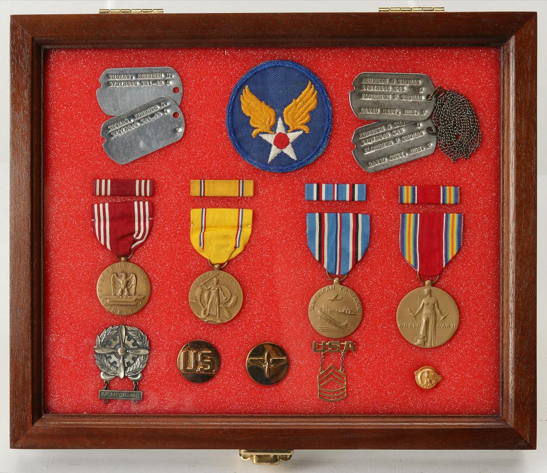 MASTER SERGEANT KENNETH THOMAS AAF DOG TAGS AND MEDALS: Master Sergeant Kenneth Thomas, AAF. Riker mount containing: AAF SSI; Two pairs of dog tags, one set with chains; Good Conduct Medal with ribbon; American Defense Medal with ribbon; American Campaign 