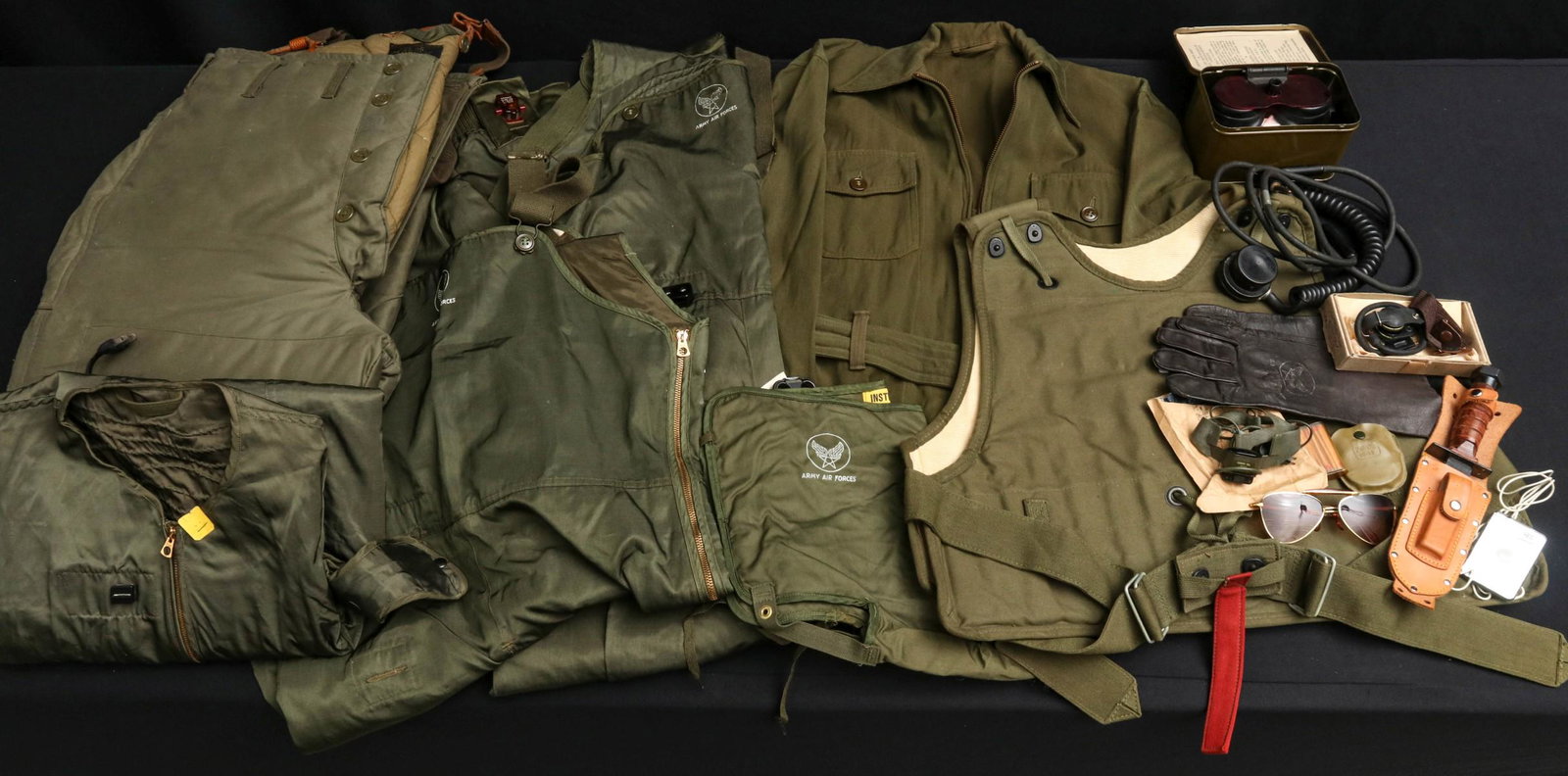 LARGE LOT OF USAAF HEATED SUIT, FLAK, GOGGLES, MIC MORE: Assorted WWII AAF items include electrically heated uniform, flak jacket, canned night goggles, flight trousers, flight suit, boxed throat mike, microphone, gloves, etc. All veteran attributions and h