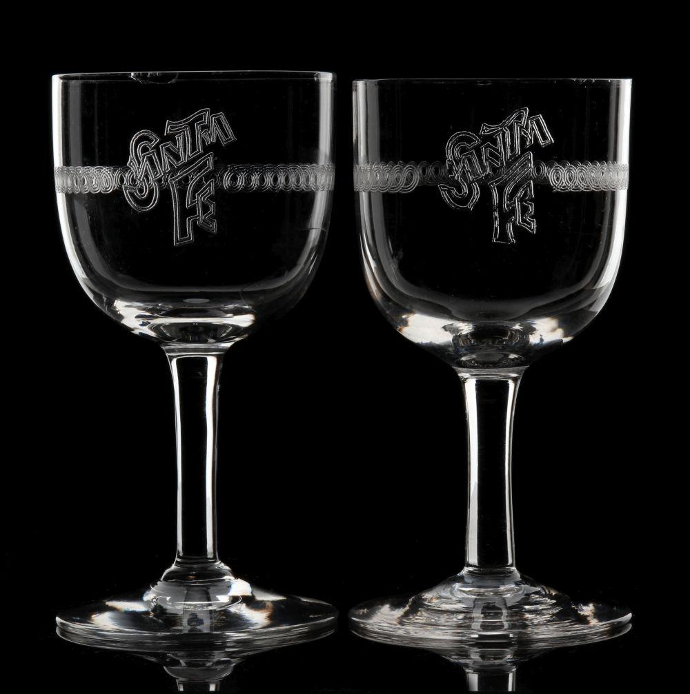 SANTA FE WINE GLASSES WITH EARLY NEEDLE-ETCHED LOGO: Two stemmed wine glasses with an early needle-etched Santa Fe logo to the sides. Measure 4.75 inches each. We happily provide seamless in-house packing and shipping services on nearly everything we se