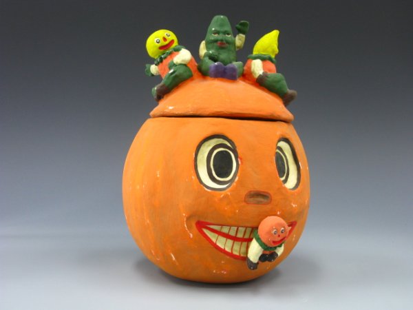 BETHANY LOWE HALLOWEEN PUMPKIN CONTAINER: Measurements of 12 x 8.5 inches. Papier-mache type Pumpkin head cookie jar with lid, this Jack-o-lantern has three veggie people sitting on lid, has label on bottom, Bethany Lowe.