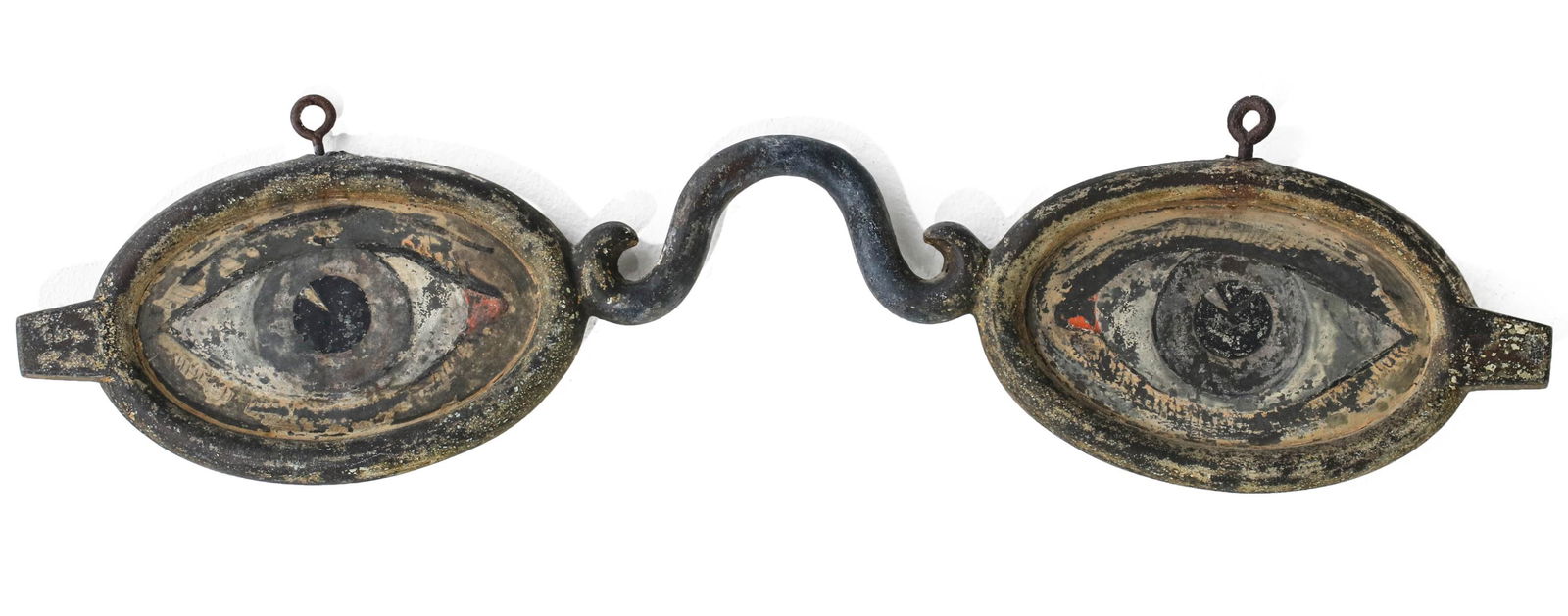 EARLY 20TH CENTURY OPTOMETRIST'S SPECTACLES TRADE SIGN: The zinc frames with painted zinc oval inserts, two-sided. Measures 6 x 23 x 0.75 inches. Provenance: The Jerry and Cathy Mueller Collection, Sioux City, Iowa We happily provide seamless in-house pack