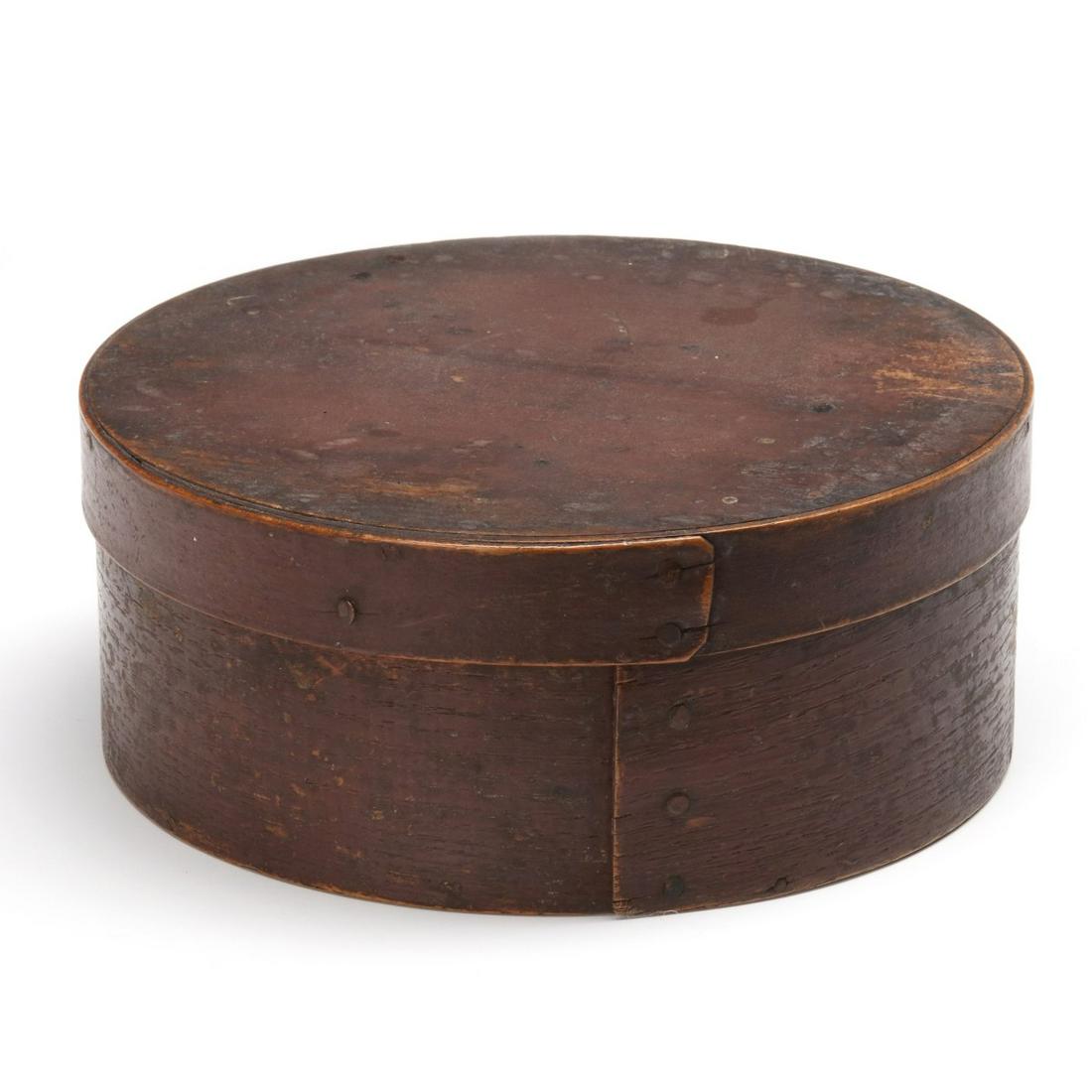 A 19TH CENTURY BENTWOOD PANTRY BOX IN DRY RED PAINT: The circular box in old, perhaps original, old, if not original, red paint, constructed with straight seams, iron tacks and wood pegs. Measures 3 x 6.75 inches. Provenance: The Jerry and Cathy Mueller