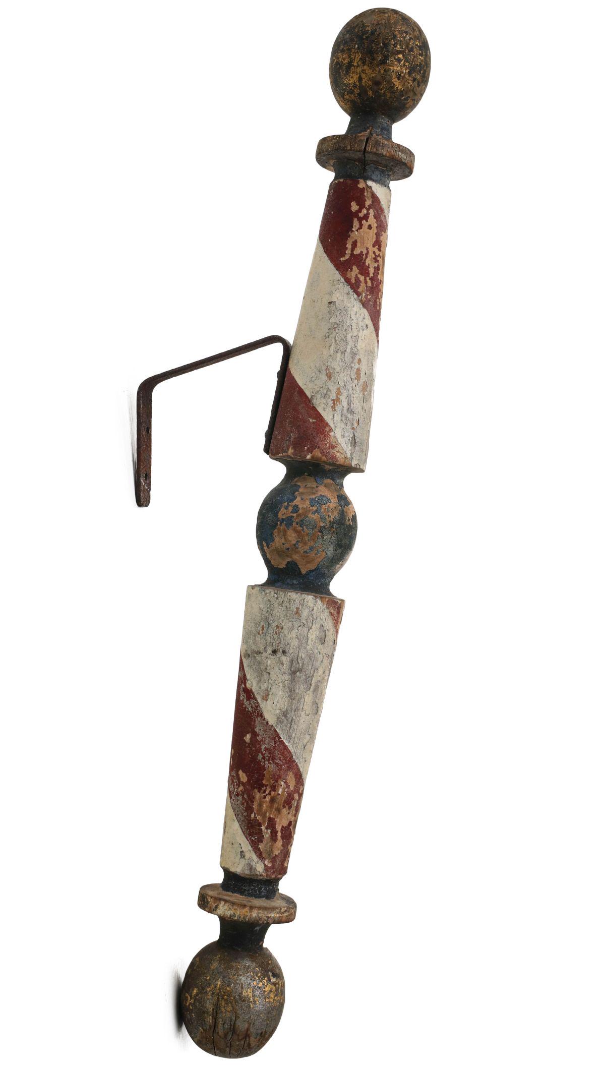 A GOOD 19TH C. WALL MOUNT BARBER POLE IN OLD PAINT: The pronounced turnings with gilded orb each end deeply grooved turnings, very much dry original red, white and blue paint, iron wall bracket. Measures 24 x 5.5 x 2.25 inches. Provenance: The Jerry an