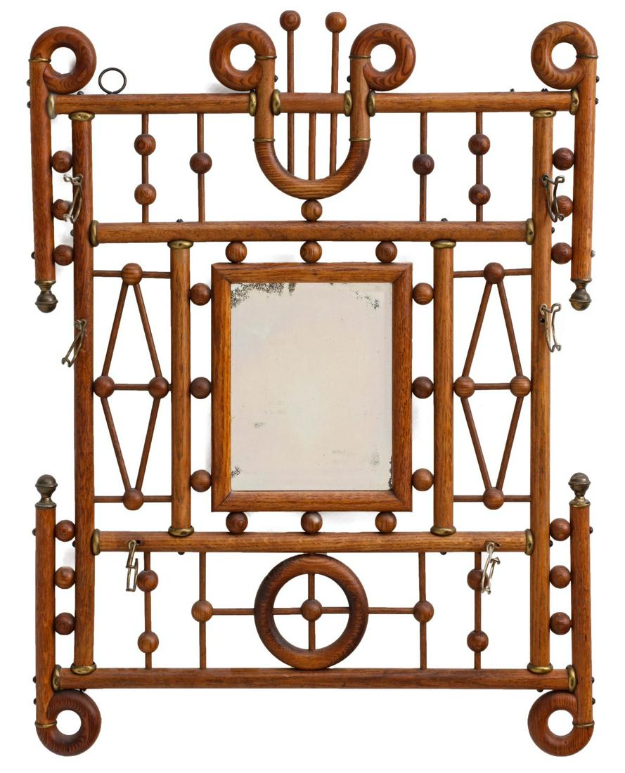 AN INTRICATE 1890s OAK STICK AND BALL COAT RACK MIRROR: The spindles, balls, circular ornaments and framework of oak with brass fittings and coat hooks, all in original finish. Measures 33 x 25.5 inches. Provenance: The Jerry and Cathy Mueller Collection,