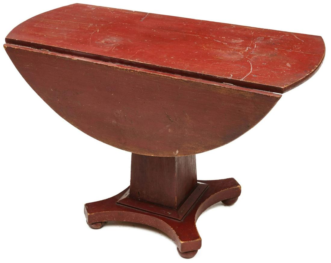 AN INTERESTING NEW ENGLAND PAINTED PINE DROP LEAF TABLE: The high country pine drop leaf center table of Empire influence with circular top and hinged drop leaves over tapering square column on quatrefoil base, yellow pine, mid 19th century. Measures 27.75 