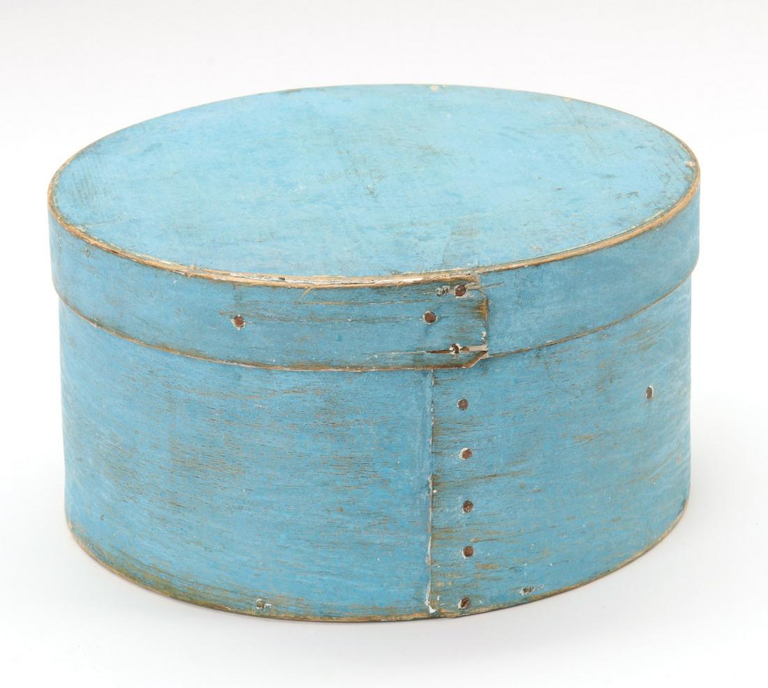 A 19TH CENTURY BENTWOOD PANTRY BOX IN OLD BLUE PAINT: The circular form constructed with tiny wood pegs and copper rose head tacks, dry blue milk paint exterior surface on the thin bent wood box. Measures 4 x 8.5 inches. We happily provide seamless in-ho