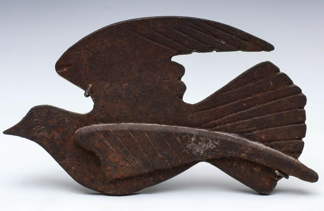 AN EARLY 20TH C. CAST IRON STYLIZED MODEL OF A DOVE: The flat silhouette casting with simple detail, possibly served as a latch, now mounted to custom made device for hanging display. Displayed on custom iron stand. Measures 5.75 x 10 inches, excluding 