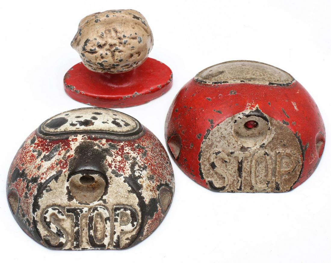 MINIATURE CAST IRON MODELS OF EARLY 'STOP' SIGNALS: Two cast iron models of traffic island with 'light' (one with red jewel, one missing) and lettered STOP on dome form iron island, lettered UNIVERSAL TRAFFIC CONTROL CO ST. LOUIS MO underside of each. 