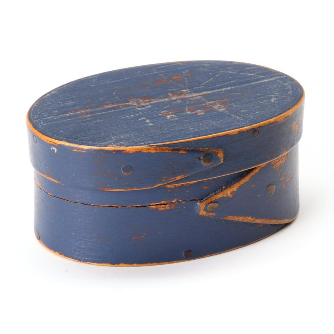 A SIGNED DATED OVAL BOX IN OLD BLUE PAINT ATTR HERSEY: The 19th century oval box with lapped construction, copper tacks, old blue milk paint, incised inscription of S H 1868 on the lid, ink attribution on the base. Measures 1.25 x 2.5 x 1.75 inches. We ha