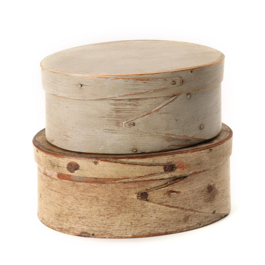 TWO 19TH CENTURY OVAL PANTRY BOXES IN OLD PAINT: Each with opposing finger laps constructed with wood pegs and rose head iron tacks, both appear to be in old paint, the larger in particular. Measures 2.5 x 6 x 4.75 and 2.75 x 6.75 x 5 inches. We hap