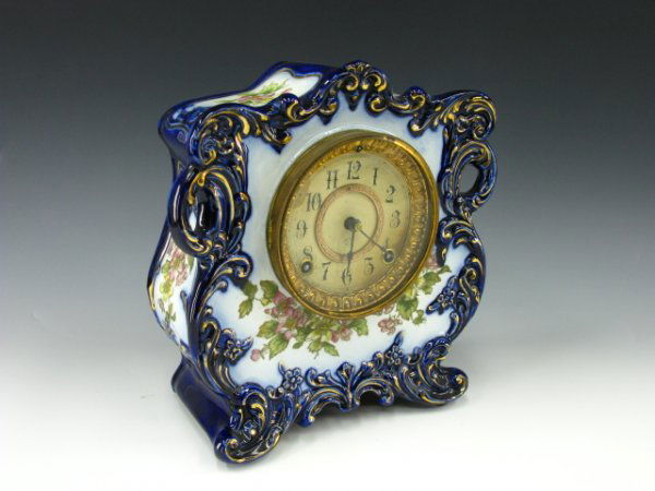 ANSONIA FLOW BLUE CHINA CLOCK TYRO PATTERN: A cobalt flow blue-type case with floral decals, Ansonia movement with original marked paper dial, cased marked TYRO. Marked 11 x 10 x 4 inches