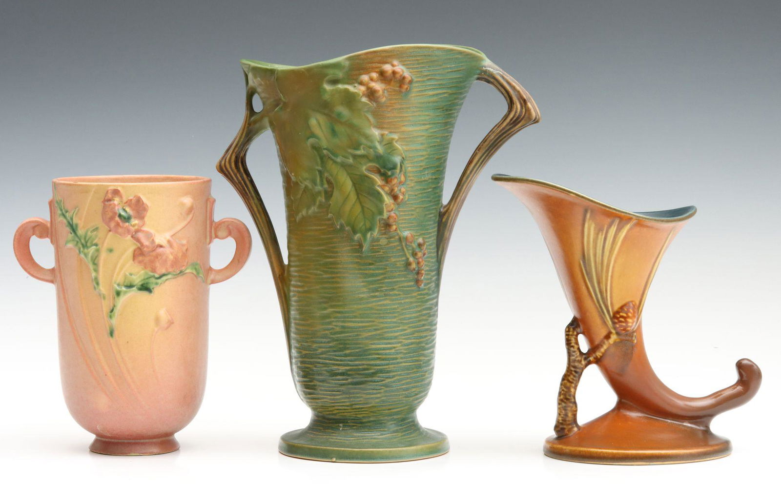 RESTORED ROSEVILLE BUSHBERRY AND PINE CONE ART POTTERY: A Bushberry vase (38-12) with restoration, a Pine Cone cornucopia (128-8) with restoration and a Poppy vase (871-8) with significant Y-shaped repair and crack; all marked under the base. Sizes range f