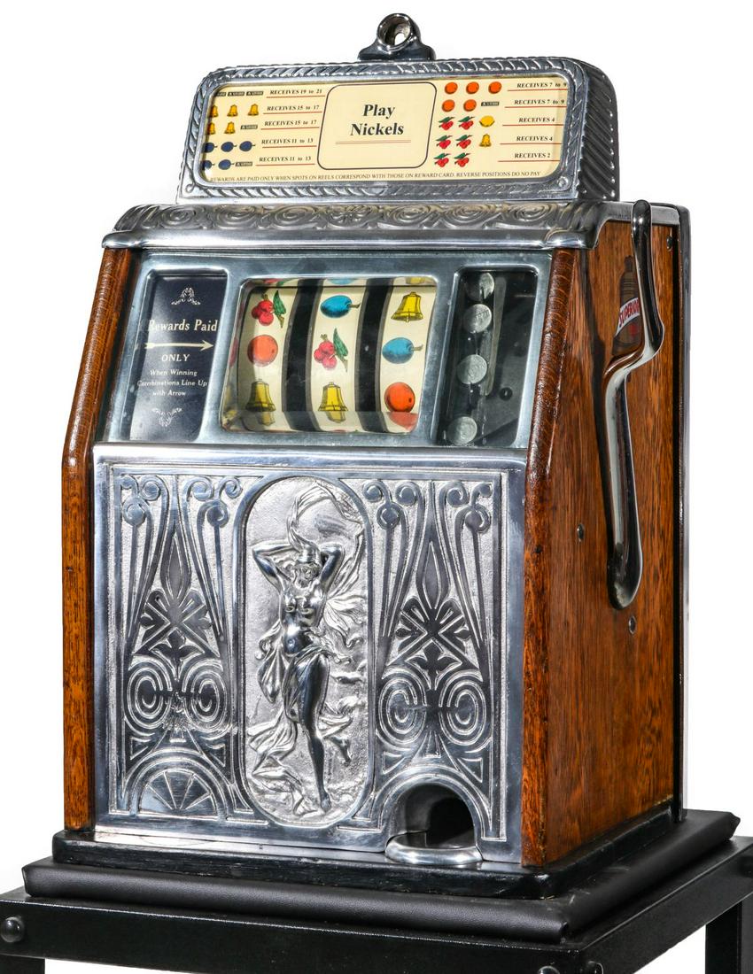 A CAILLE BROS. SUPERIOR BELL 5 CENT SLOT MACHINE: The 1920s Caille Brothers nickel slot machine designed with semi-clad maiden in bas relief centering the front casting, Superior Bell decals on each side, a contemporary steel stand is included. Measu