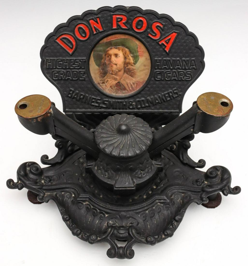 DON ROSA CAST IRON COUNTERTOP ADVERTISING CIGAR CUTTER: The ornate cast iron double cigar cutter with central marquee centered by a lithograph portrait of a bearded gentleman reads 'Don Rosa, Highest Grade Havana Cigars, Barnes, Smith & Co. Makers.' in emb