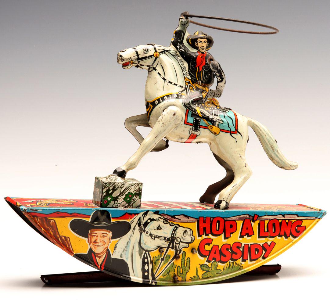 A HOPALONG CASSIDY 'RANGE RIDER' LITHOGRAPHED TIN TOY: The Marx brand toy with wind up mechanism rocks and the lasso rotates above the figure of Hoppy. Measures 9.5 x 11 x 2.25 inches. We happily provide seamless in-house packing and shipping services on