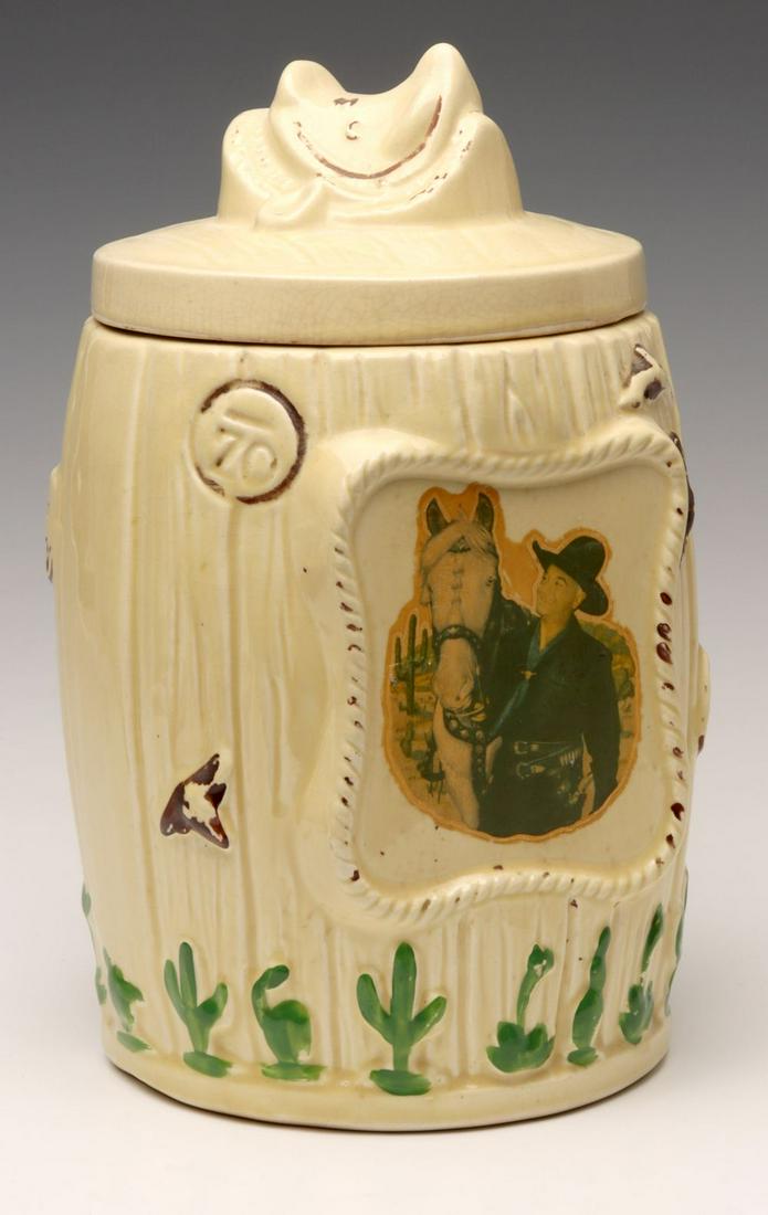 A MID 20TH CENTURY HOPALONG CASSIDY COOKIE JAR: The pottery jar with paint over glaze decoration and central decal image over the glaze within rope twist frame. Measures 12 x 6.5 inches. We happily provide seamless in-house packing and shipping ser