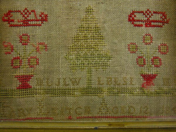 AN 1846 AMERICAN SCHOOLGIRL NEEDLEWORK SAMPLER: Samples of stitching in lines of letters and numbers over potted flowers and a tree, the name of MARY LEITCH AGED 12 1846 across the bottom, 12 x 21 1/2 inches.