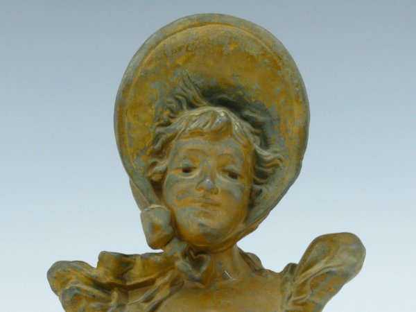 A SPELTER FIGURE OF WOMAN IN BONNET: Cast metal, remnant brown paint finish. Felt coming off bottom, unmarked. Measures 8 inches.