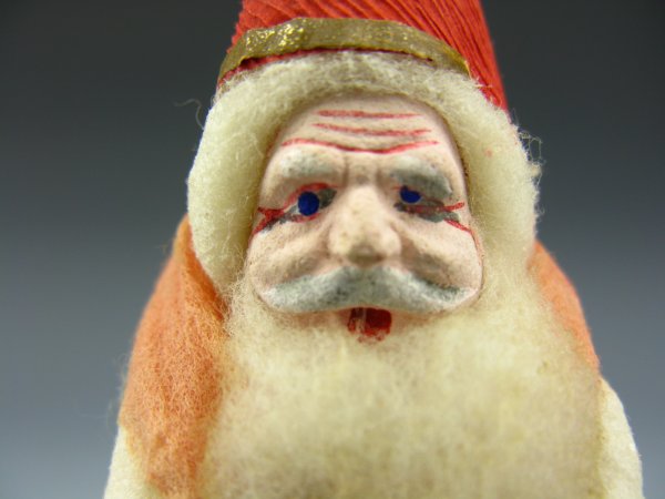 WHITE COTTON FATHER CHRISTMAS BISQUE ORNAMENT: Measures 6 inches, white cotton with red crepe paper pointy hat, painted composition face, pink cotton trim.