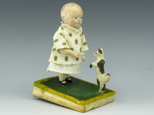 A 19TH C. ANIMATED GIRL & PUPPY PIPSQUEAK TOY: Papier mache' figures on a bellow platform, the action includes shifting of the girl's torso as the bellows are pushed downward, a great animated toy that measures 6 x 3.5 x 4 inches. Bellows in base,