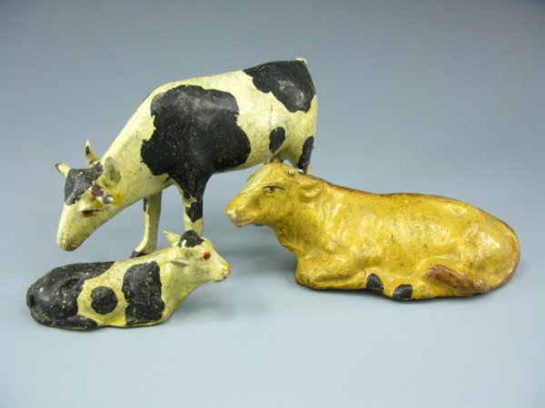 THREE EARLY 1900'S PAPIER MACHE COWS: Largest about 3 x 4.75 inches, plus 2 x 4.75 inches, and 1.25 x 2.5 inches.