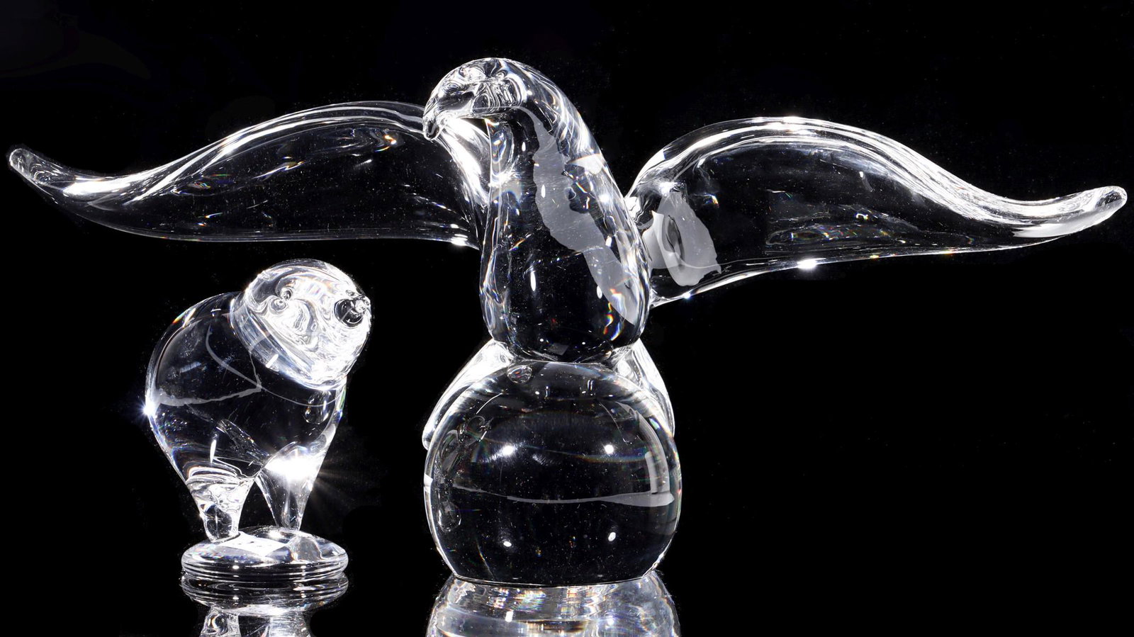 STEUBEN CRYSTAL FIGURES OF EAGLE AND CHICK: Circa 1964 Engraved signatures on the underside of the base of each. Measure 6 x 13 and 4 x 3 inches. Provenance: The Topeka and Shawnee County Public Library We happily provide seamless in-house pack