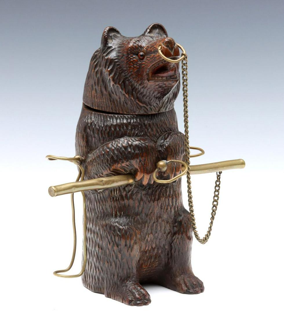 AN EARLY 20TH C. BLACK FOREST CARVED BEAR PIPE STAND: The carved wood figure with brass apparatus to hold smoking pipes, the figure is hollowed and hinged with brass at the shoulders to serve as tobacco container and humidor. Measures 9 x 6 x 8 inches. W