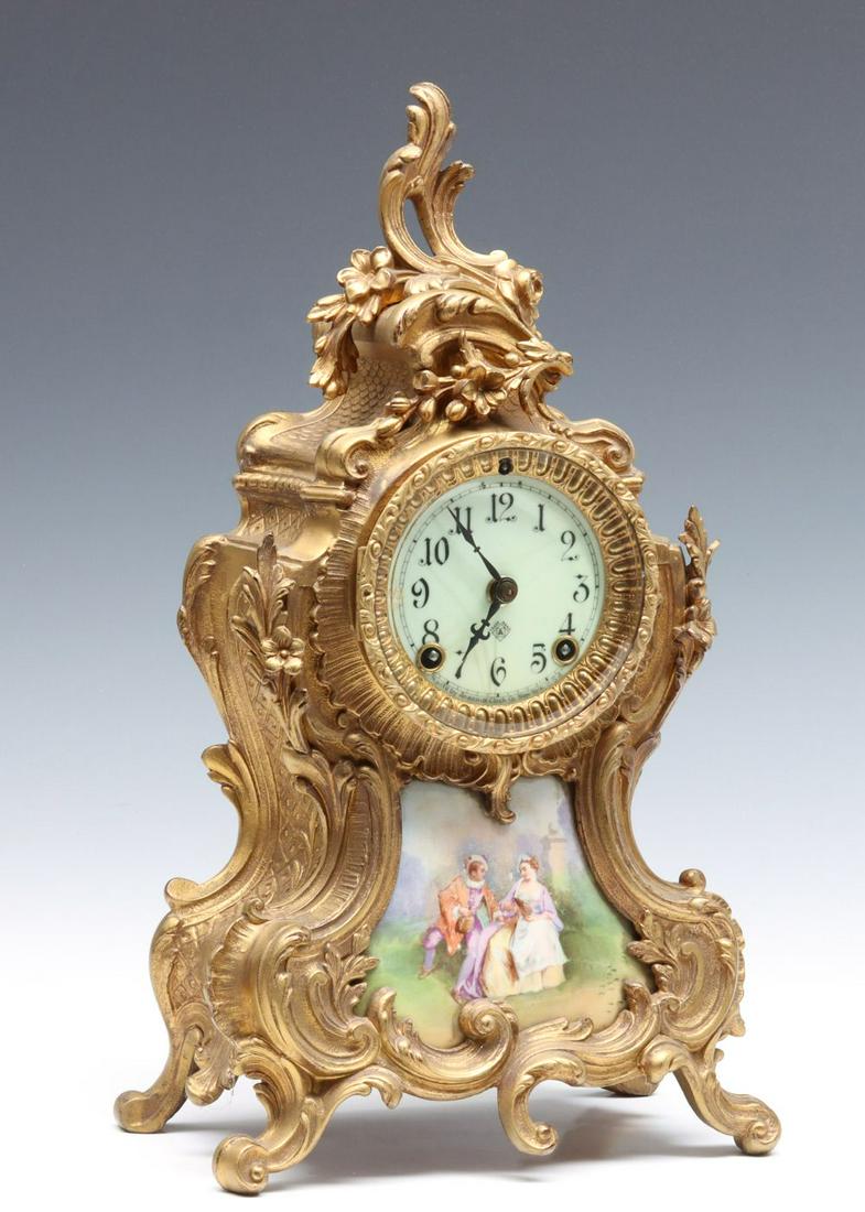 A FRENCH ROCCOCO STYLE CLOCK SIGNED ANSONIA: The ornate gilded spelter case with porcelain enamel dial, time and strike movement and porcelain inset tablet, signed on the dial and movement. Measures 15 x 8 x 5 inches. We happily provide seamless