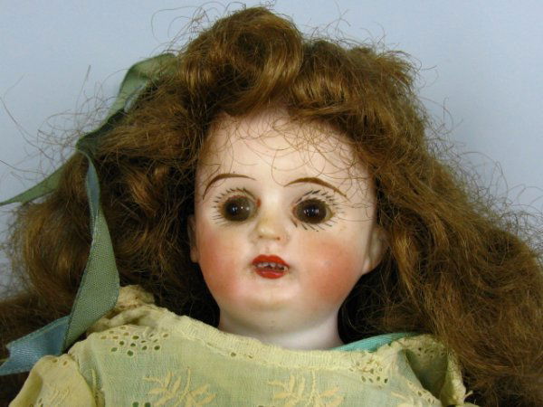 GERMAN BISQUE HEAD CHARACTER DOLL: Shoulder plate head with impressed marks of D.K. Dep 4/0 bisque arms and legs. Glass eyes, 12.5" overall.