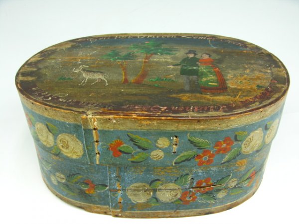 AN UNUSUAL EARLY PAINTED BRIDE'S BOX WITH FIGURES: Measures 8 x 11.5 x 18 inches, oval shaped with original Prussian blue base and full color floral designs on sides. The top section has an unusual scene with figures and a got in landscape with verse 