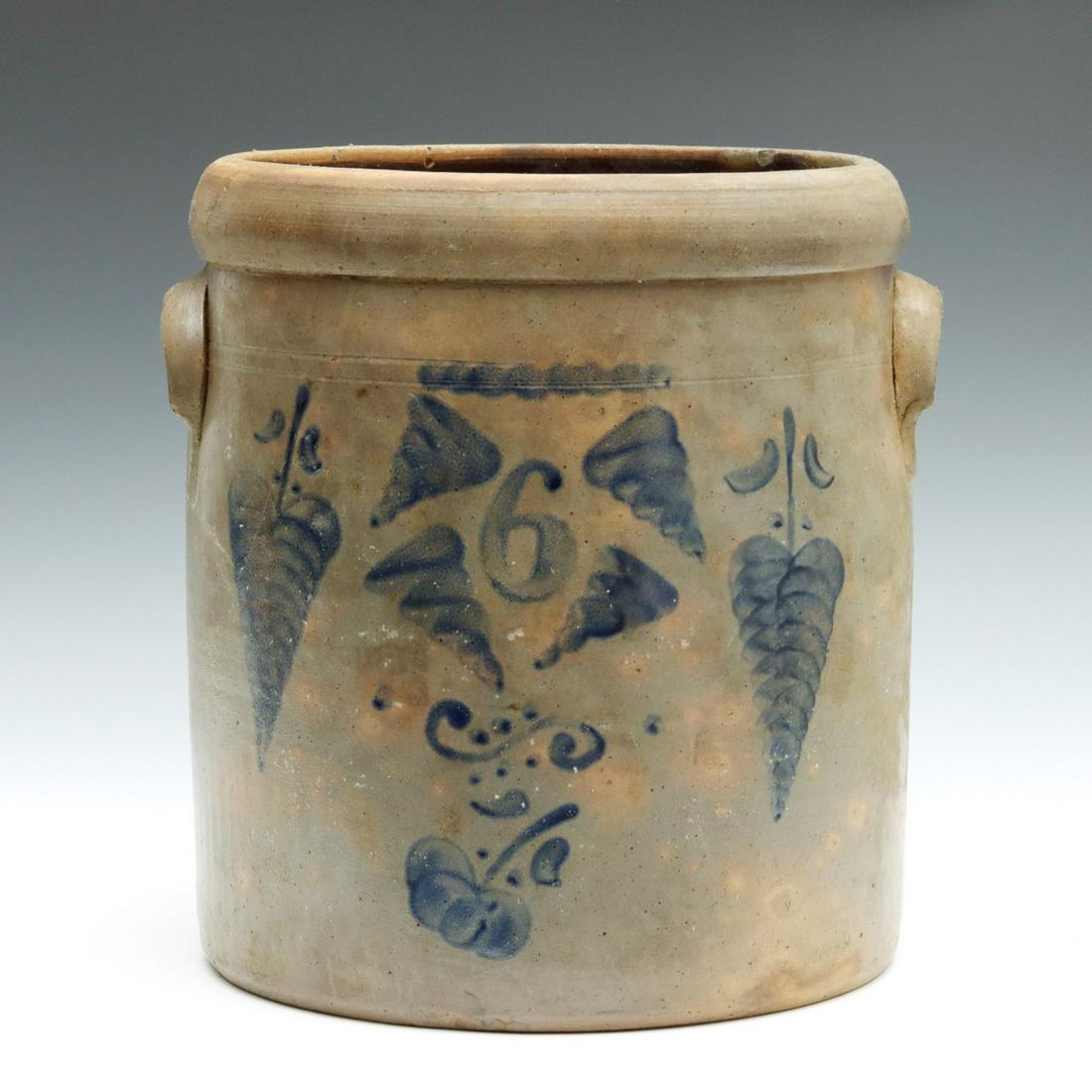 AN OPEN STRAIGHT-SIDED CROCK WITH FREEHAND DECORATION: The wide, half-round tooled rim over incised lines, lug handles and freehand numeral 6 surrounded by whimsical leaves and whirlwinds over a flourish and downward facing flower blossom, salt glaze, no 