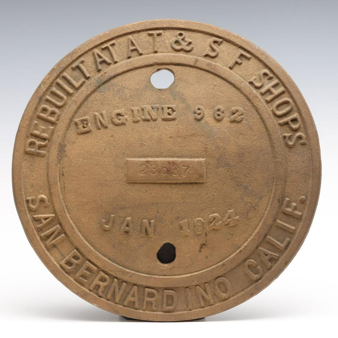 A BRASS SANTA FE SHOPS BUILDER'S PLATE FOR ENGINE 962: The cast brass plate for the Santa Fe 2-10-2 engine number 962 originally built in 1904 and obviously rebuilt at the San Bernardino shops in 1924. Measures 12.5 x 0.5 inches. We happily provide seamle